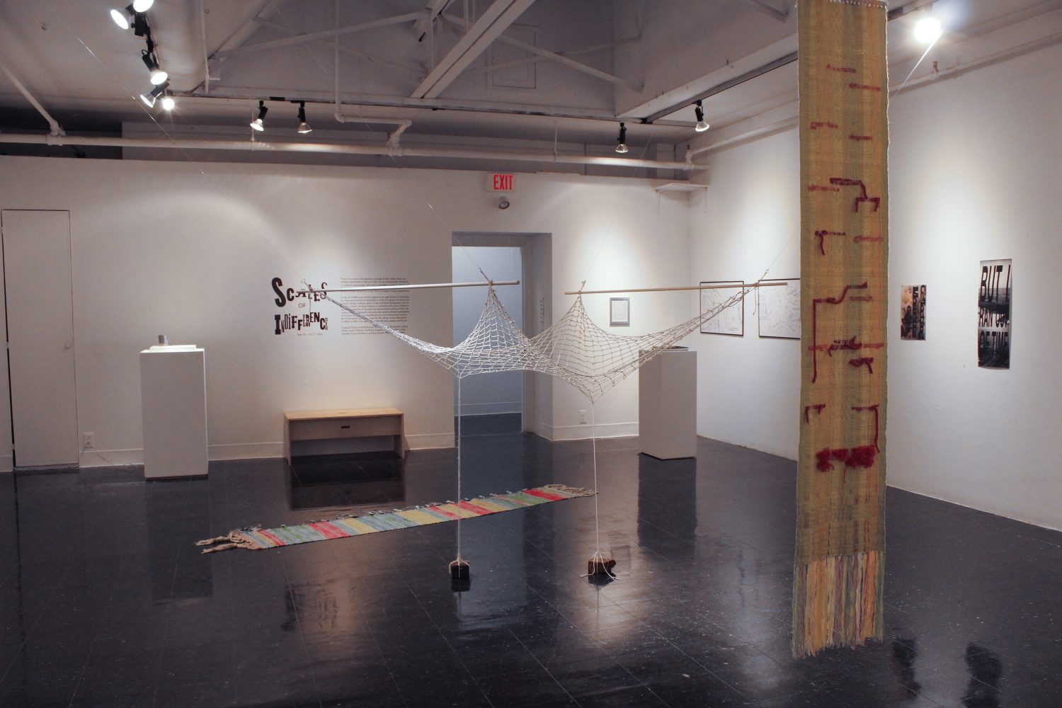 installation image of Scales of Indifference exhibition at The Anderson - hanging textile works