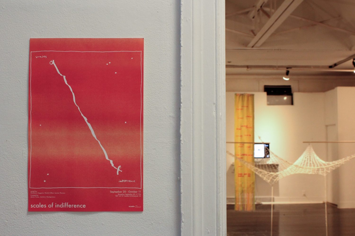 exhibition poster on white wall with gallery space in background