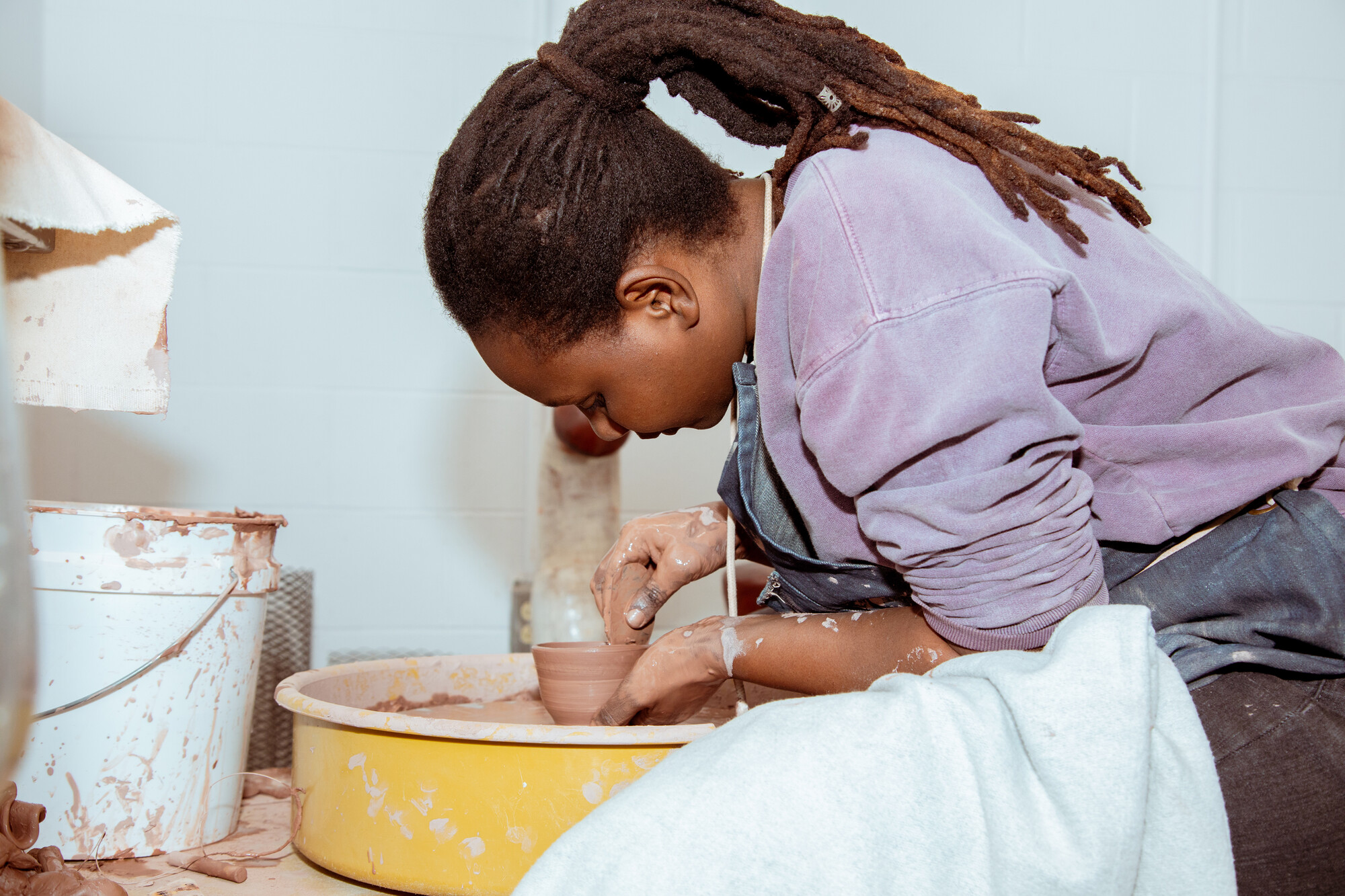 A student at the pottery wheel in her studio