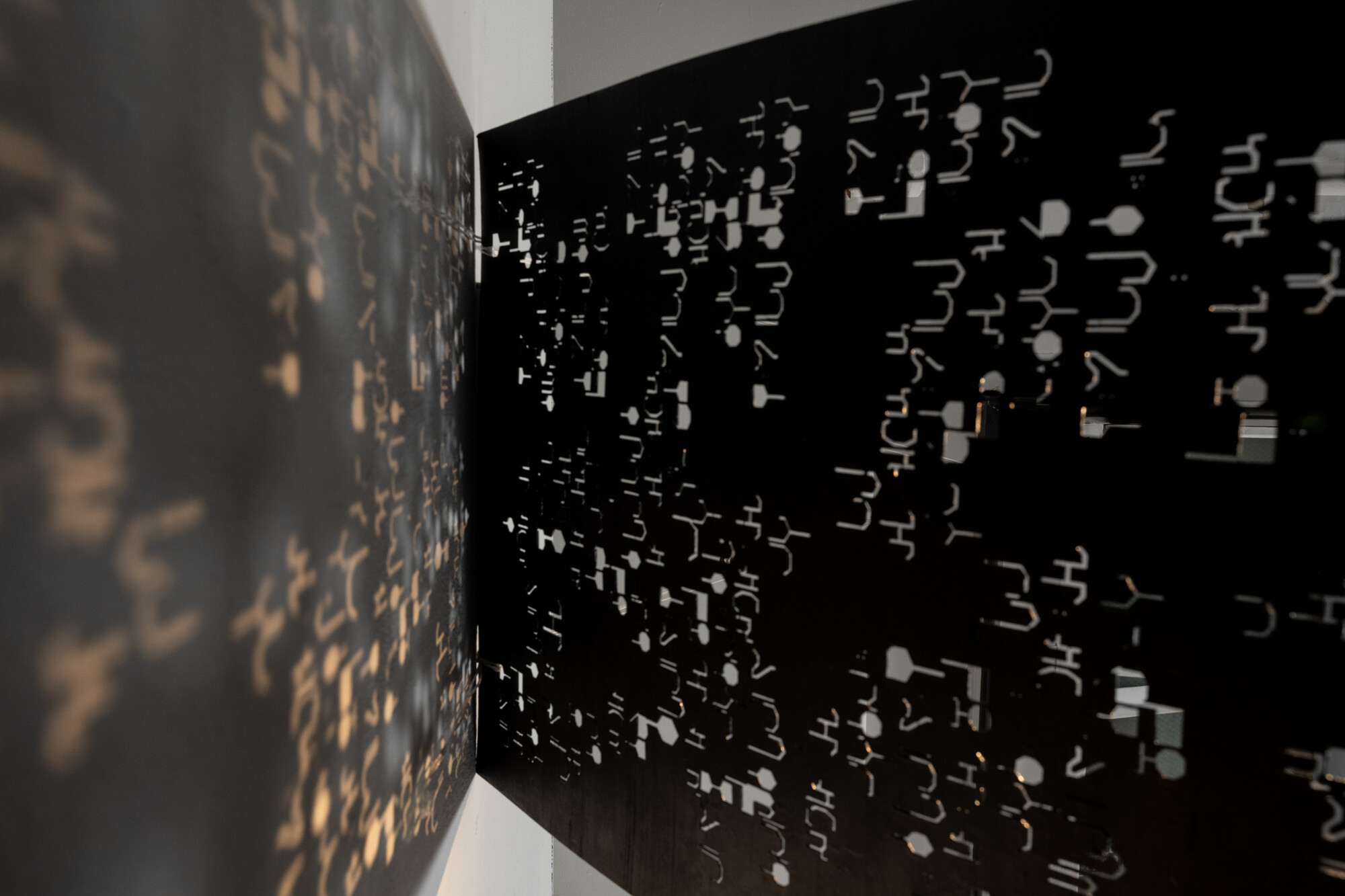 detail of a sculpture made of draped, black paper with cut outs