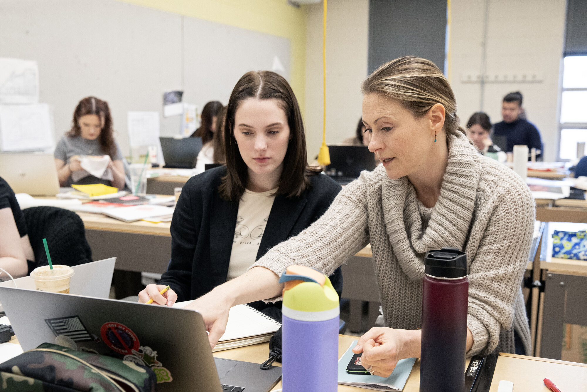 Interior design professor assisting student in the classroom