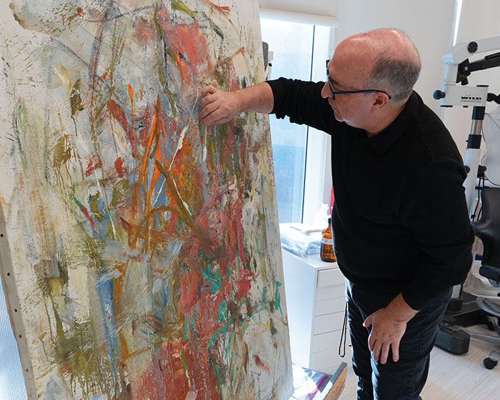 Conservator Scott Nolley cleaning a painting
