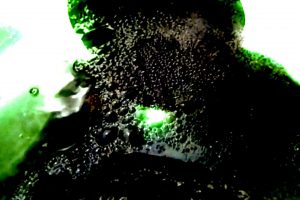 Black and green image, blurry, displaying texture that looks like bubbles.
