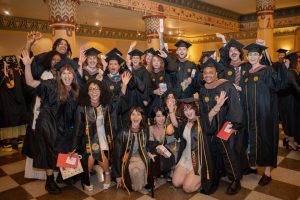 A group of 2026 VCUarts graduates in caps and gowns posing together after Commencement celebration at Altria Theater.