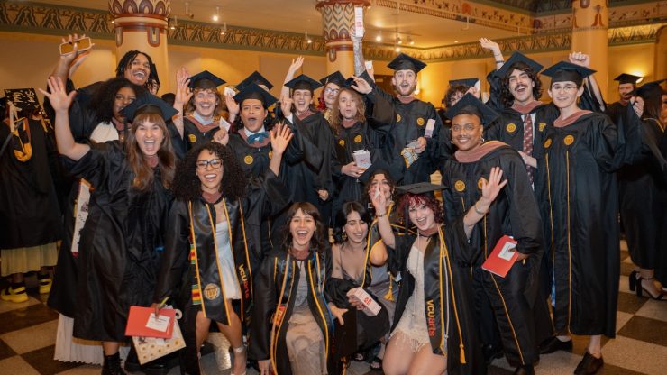 A group of 2026 VCUarts graduates in caps and gowns posing together after Commencement celebration at Altria Theater.