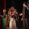 A graduate walks across the stage of the Altria Theater.