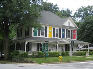 A suburban house with colorful banners hanging in between its windows.