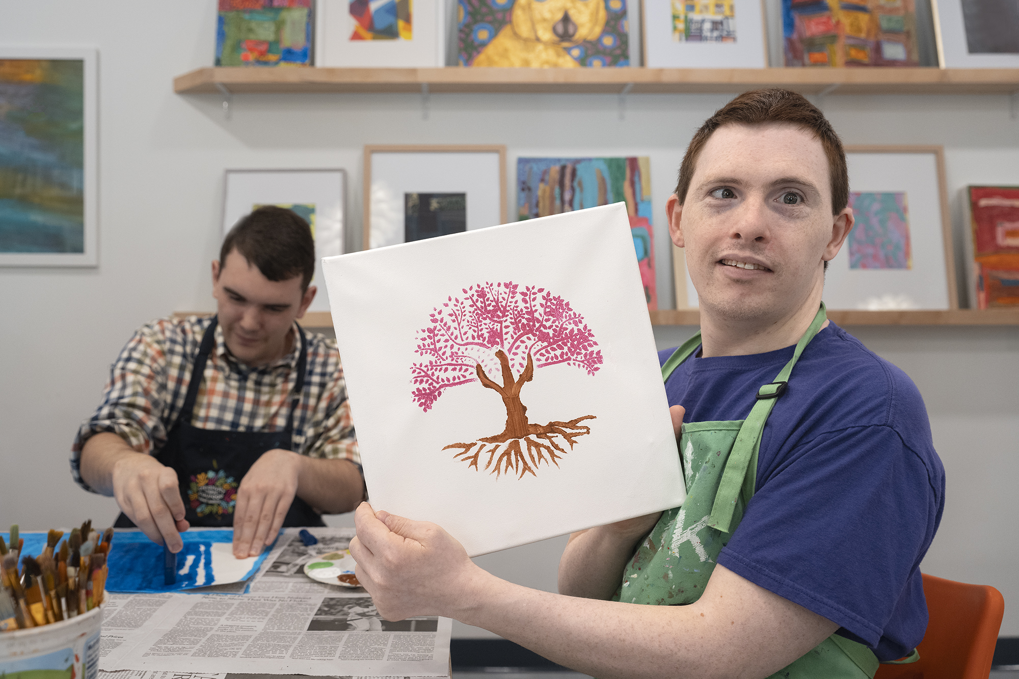 Portrait of a student and their artwork during a class at The Arc Studio