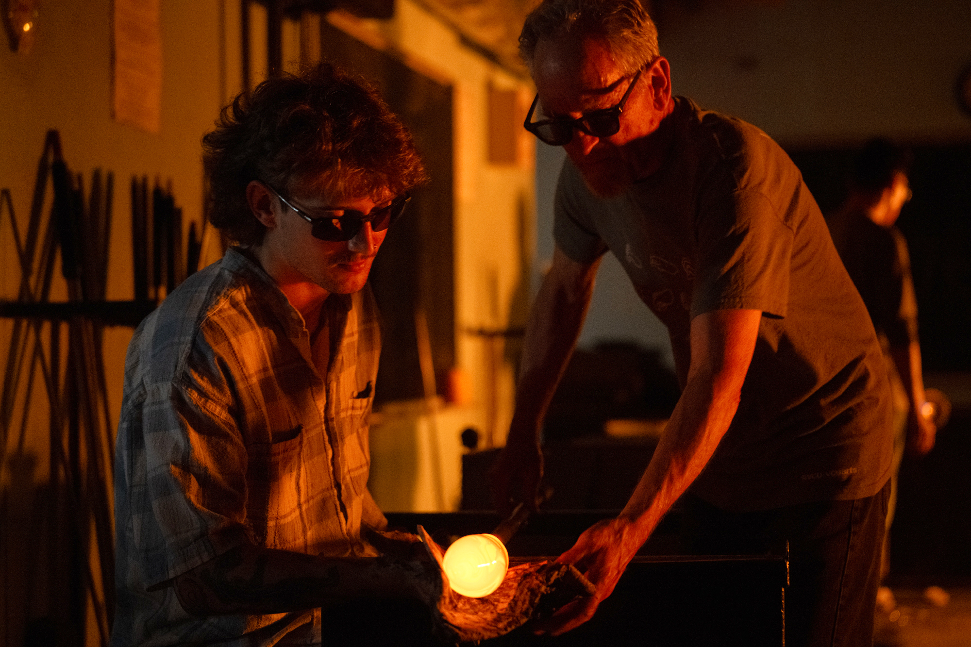 A student and professor Jack Wax work together in the glass shop
