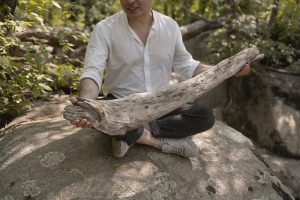 David Guarnizo holds found driftwood on Richmond's Belle Isle