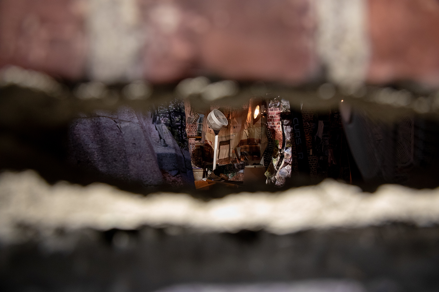 hole in brick wall with fan